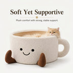 Ginger cat sitting inside the plush coffee cup cat bed